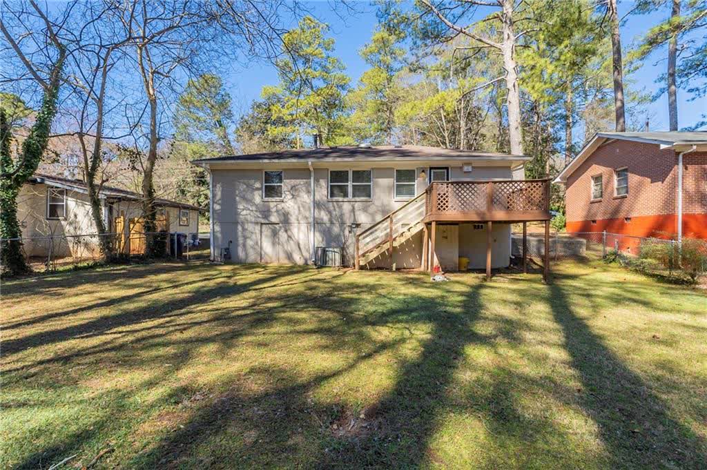 Back of the house, with the raised deck, its stairs and the backyard
